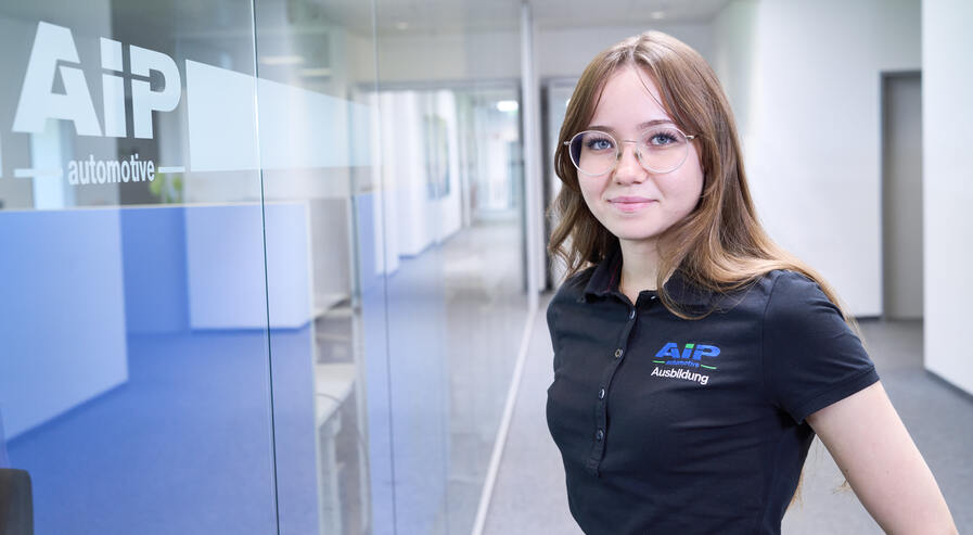 Auszubildende schaut in die Kamera und lächelt.