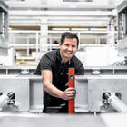 Lachender Mitarbeiter in Industriehalle