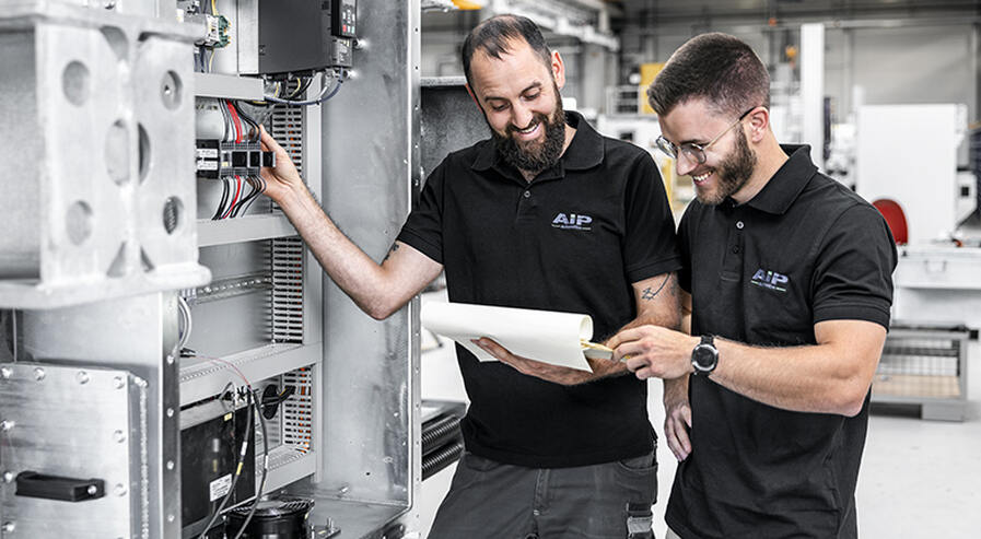 Two technicians read the circuit diagram.